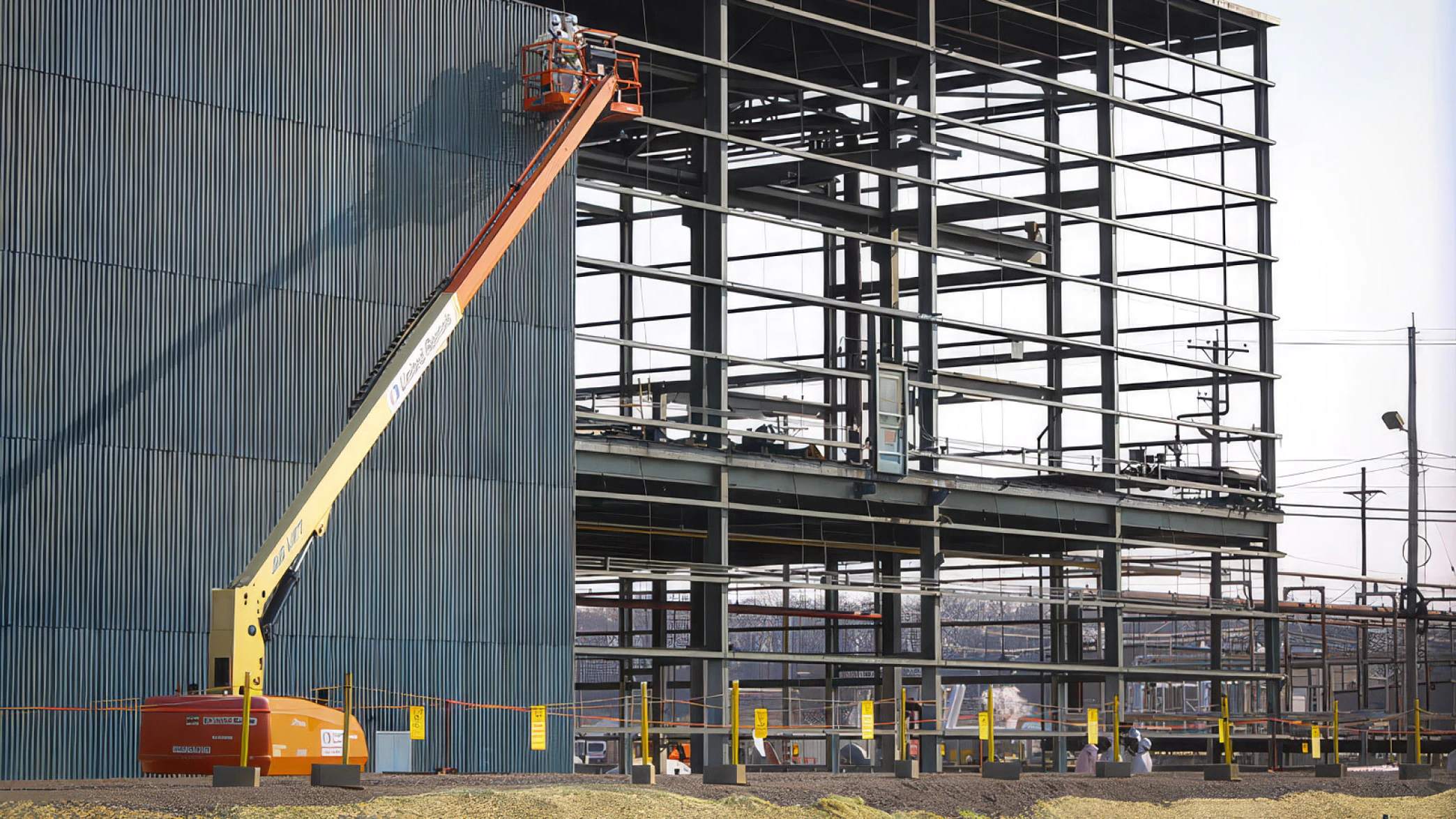 Metal structure under construction with a crane.