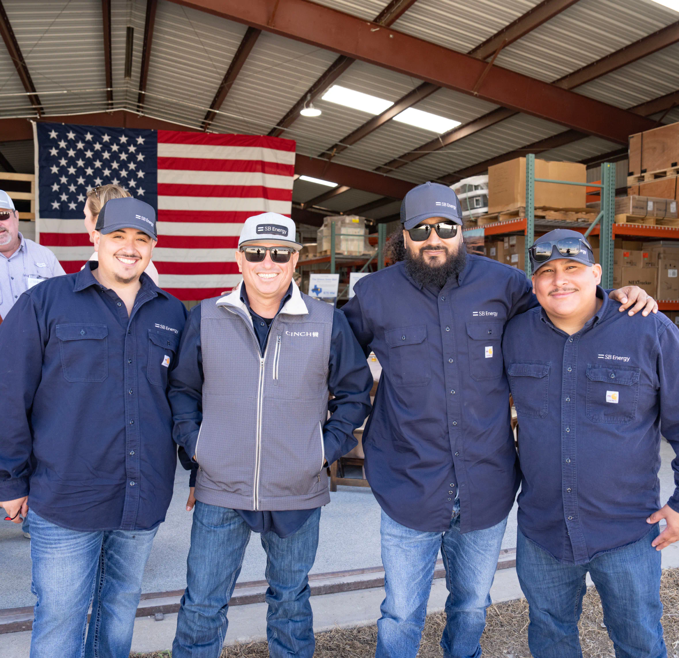 SB Energy workers smiling in front of a US flag.