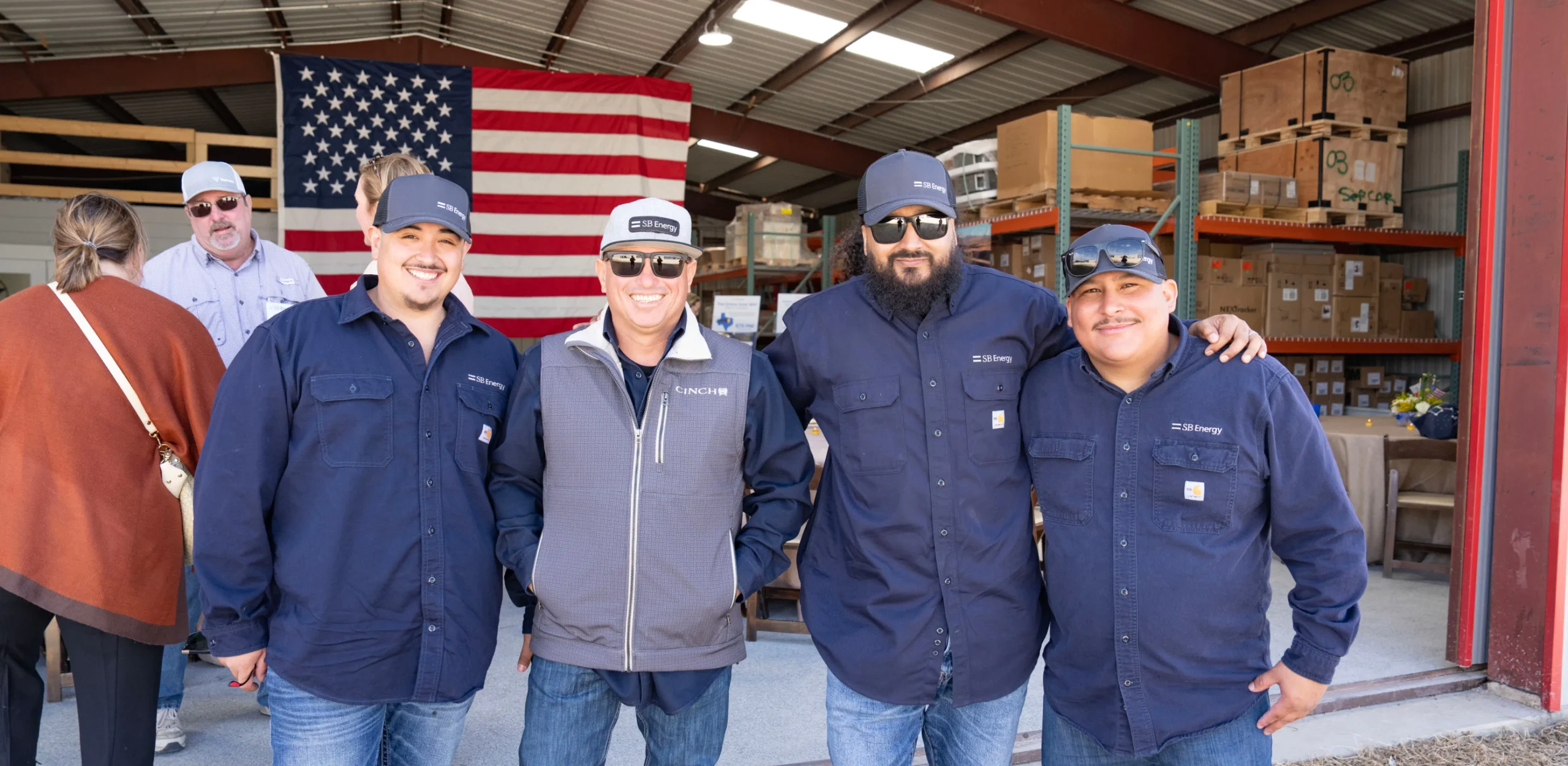 SB Energy workers smiling in front of a US flag.
